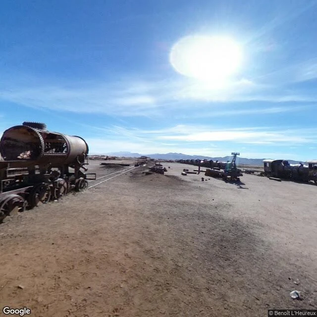 rusted trains on a salt flat under a cobalt sky
