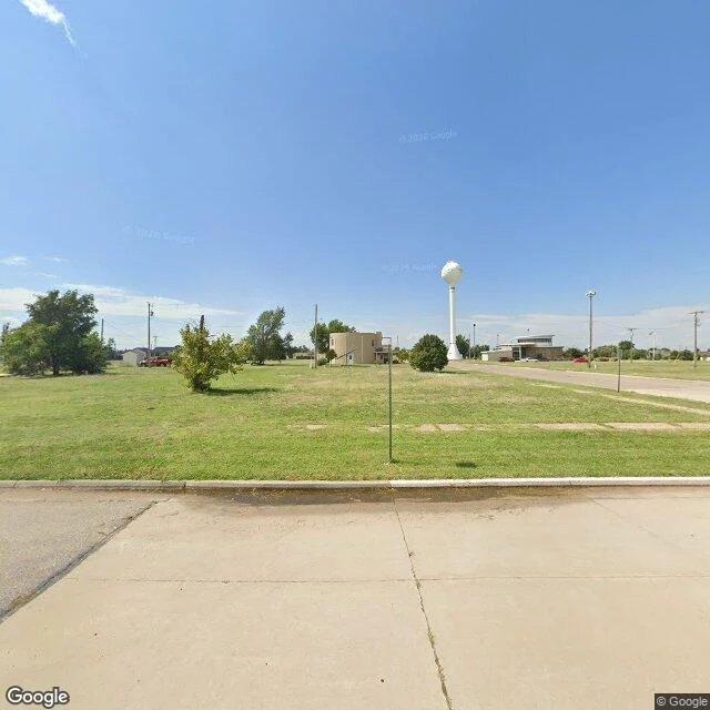 The same spot, turned around: mown grass, old sidewalks, the water tower